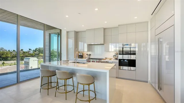 a kitchen with stainless steel appliances granite countertop a stove a sink a microwave a dining table and chairs