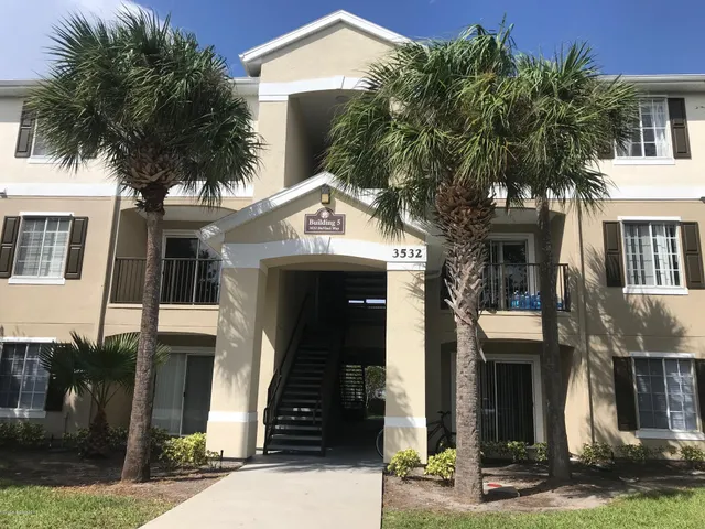 a front view of a house with a tree