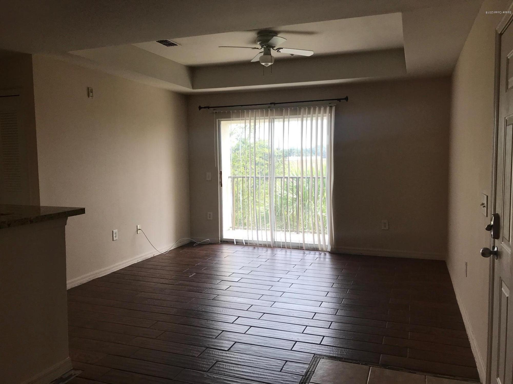 3532 D'Avinci Way, Unit 3015 Melbourne, FL 32901 - Photo 6 of 20 a view of an empty room with wooden floor and a window