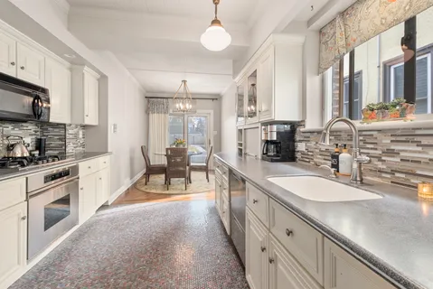 a large kitchen with stainless steel appliances granite countertop a lot of counter space and a sink