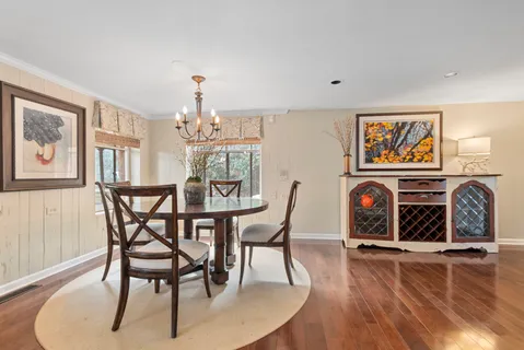 a dining room with furniture a chandelier and wooden floor