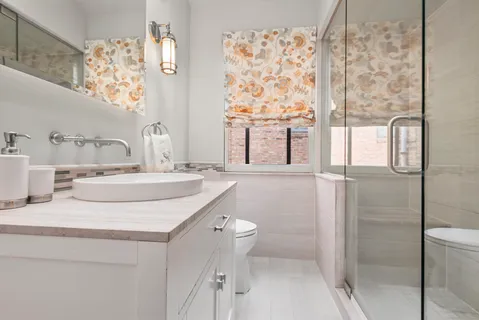 a bathroom with a granite countertop sink a toilet and shower