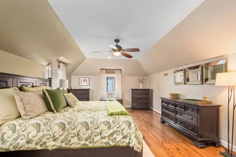 a bedroom with a large bed and a chandelier