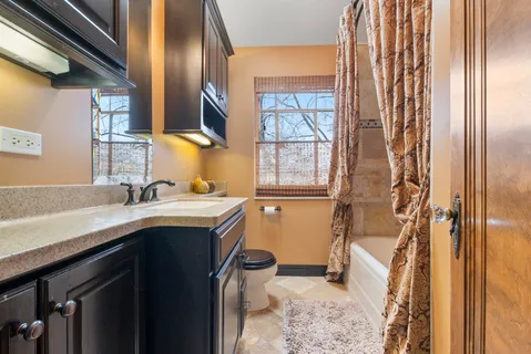 a bathroom with a granite countertop sink toilet and shower