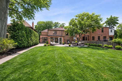 a view of a house with a big yard plants and large trees