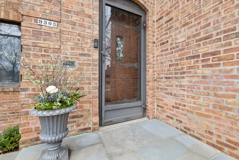 a view of a door of the house with a potted plant