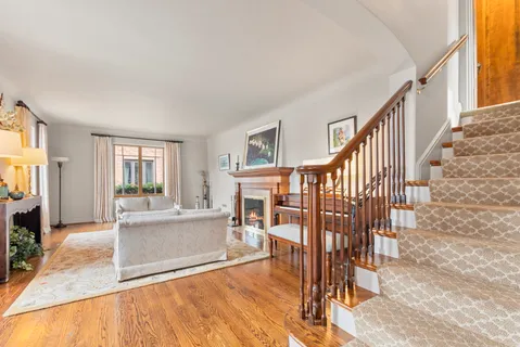 a view of a livingroom with furniture wooden floor and staircase