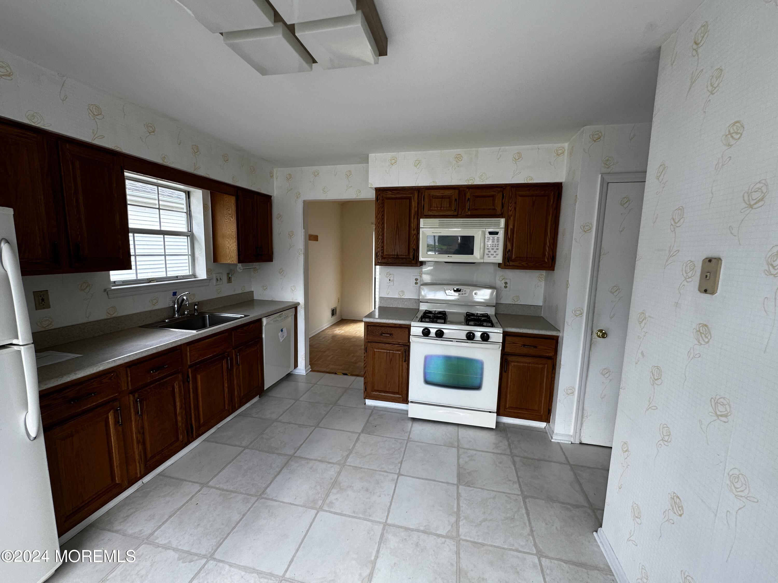 101 Almond Road Freehold, NJ 07728 - Photo 11 of 12 a large kitchen with stainless steel appliances granite countertop a stove and a sink