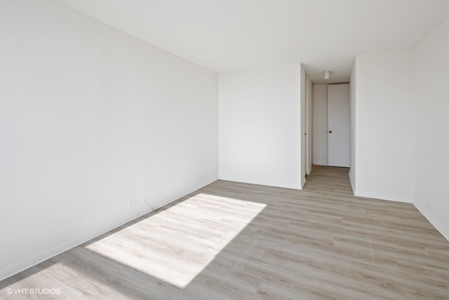 360 East Randolph Street, Unit 1002 Chicago, IL 60601 - Photo 14 of 18 a view of an empty room and wooden floor