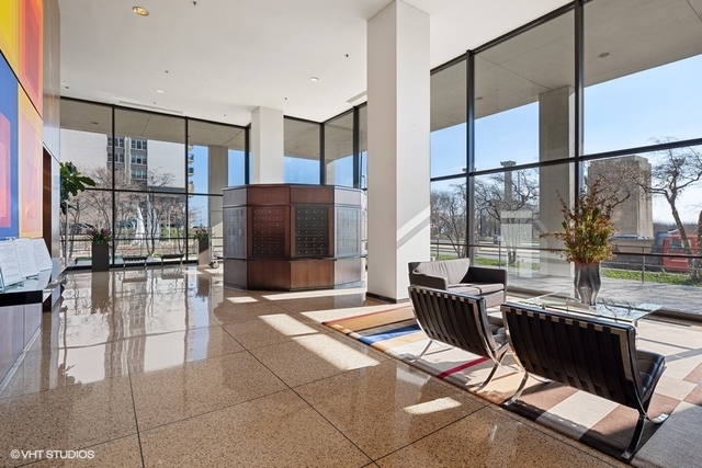 360 East Randolph Street, Unit 1002 Chicago, IL 60601 - Photo 3 of 18 a living room with furniture a large window and stainless steel appliances