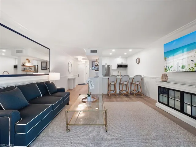 a living room with furniture and a dining table with wooden floor