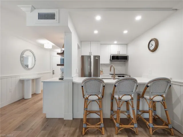 a living room with furniture a flat screen tv and kitchen view