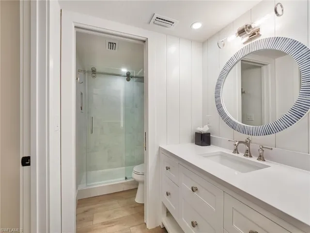a bathroom with a toilet a sink and a mirror