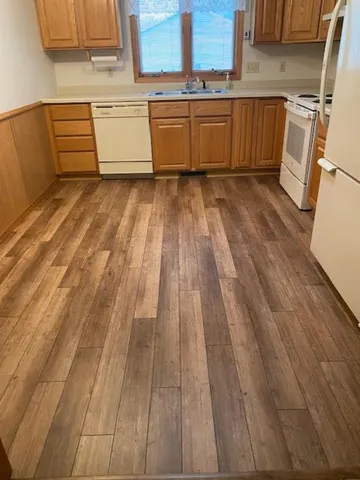 a view of a kitchen with wooden floor and electronic appliances
