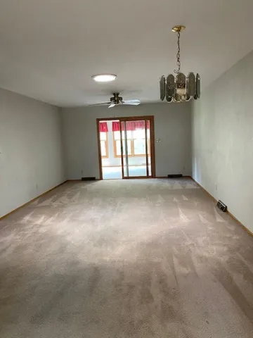 an empty room with windows and ceiling fan