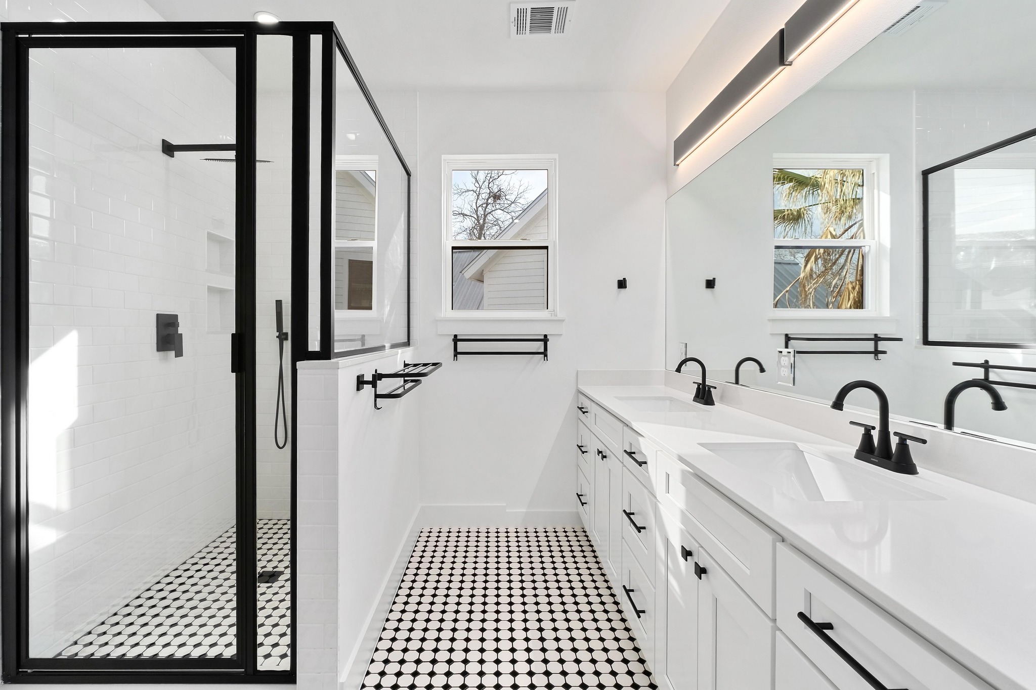 1500 Sylvan Glade, Unit 2A Austin, TX 78745 - Photo 15 of 29 a bathroom with a double vanity sink a toilet a mirror and shower