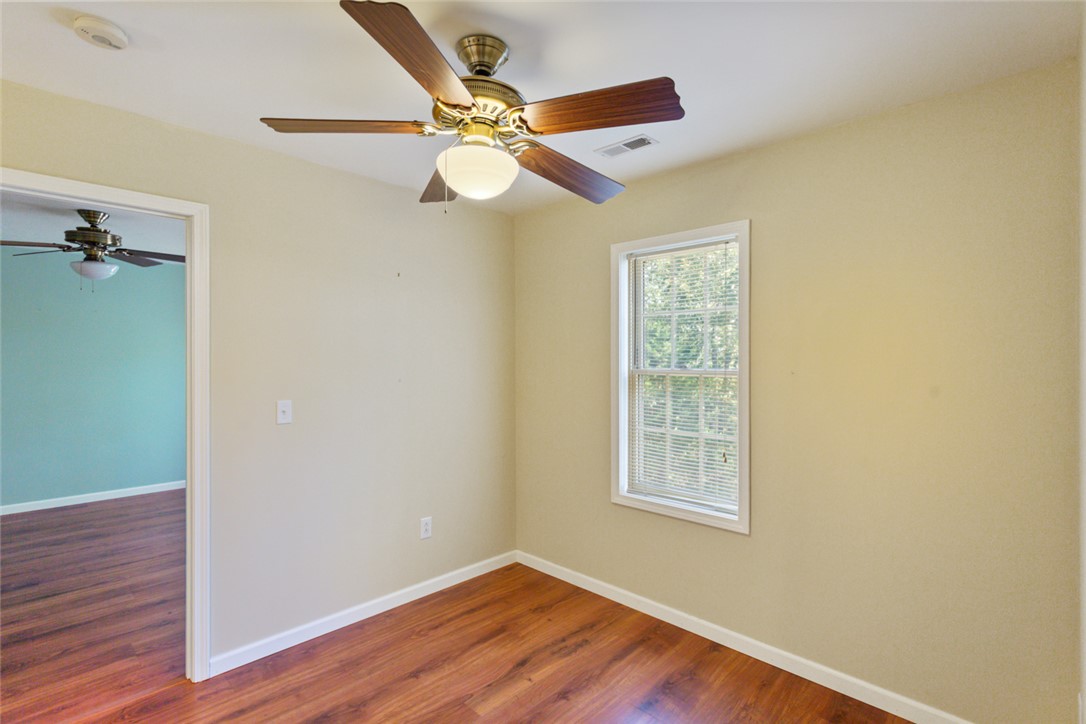 621 Burns Mill Road West Union, SC 29696 - Photo 7 of 45 Hardwood flooring extends throughout this cozy bedroom, illuminated by a window overlooking nature.