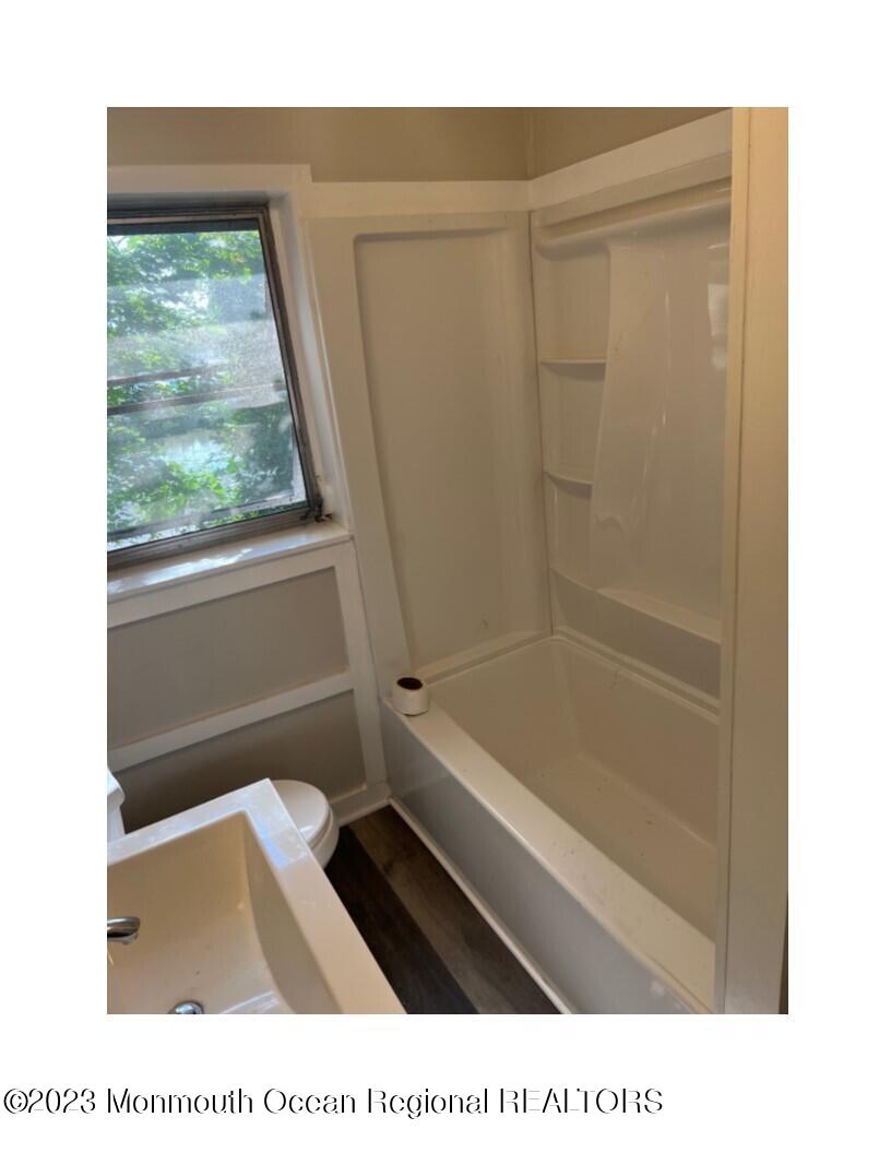 105-107 Atlantic Street Bridgeton, NJ 08302 - Photo 11 of 20 a bathroom with a toilet a bath tub and a window
