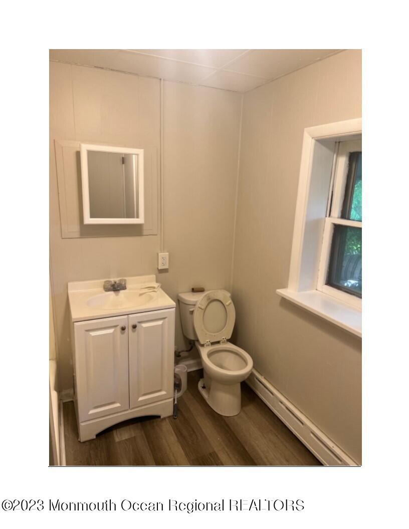 105-107 Atlantic Street Bridgeton, NJ 08302 - Photo 16 of 20 a bathroom with a sink toilet a mirror and vanity