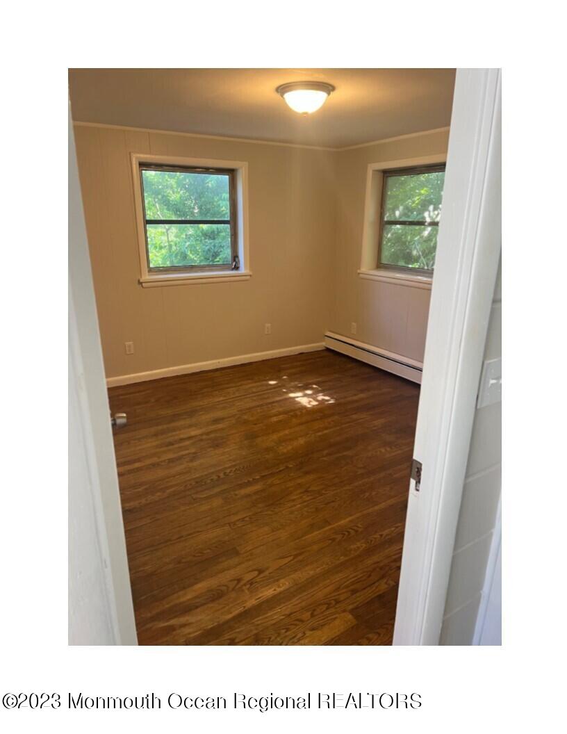 105-107 Atlantic Street Bridgeton, NJ 08302 - Photo 7 of 20 a view of an empty room with wooden floor and a window