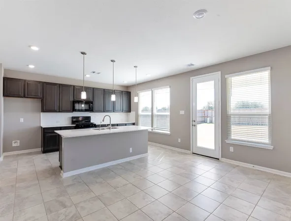 a kitchen with stainless steel appliances granite countertop a stove top oven a sink a counter top space and cabinets