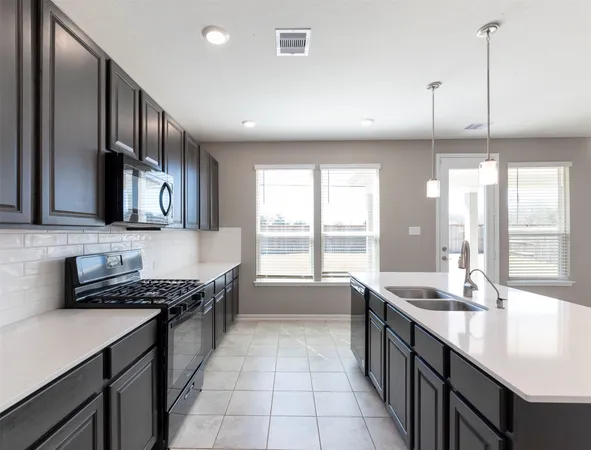 a kitchen with stainless steel appliances granite countertop a sink a stove and a wooden floors