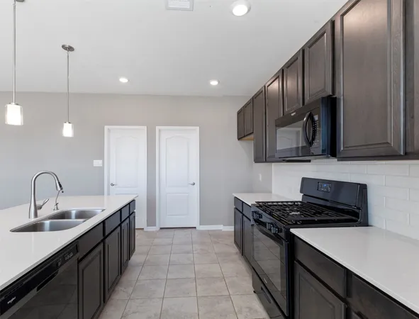 a kitchen with stainless steel appliances granite countertop a sink a stove and a wooden floors