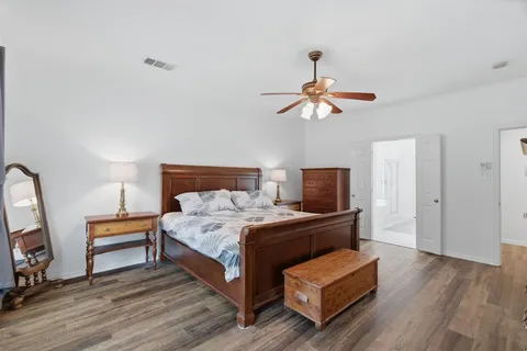 a bedroom with a bed a flat screen tv and a chandelier