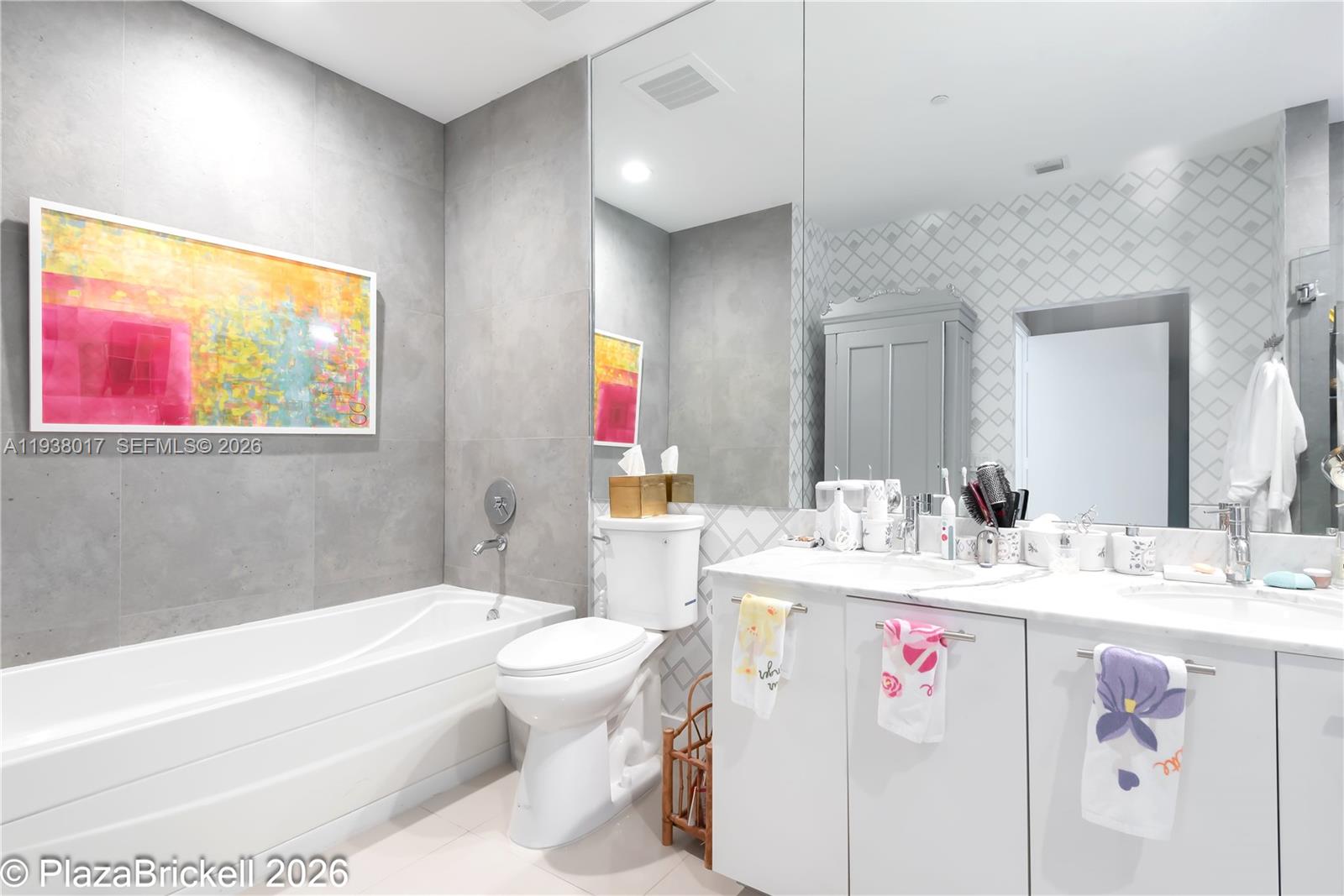 950 Brickell Bay Drive, Unit 5505 Miami, FL 33131 - Photo 20 of 63 a bathroom with a granite countertop sink a toilet a mirror and bathtub