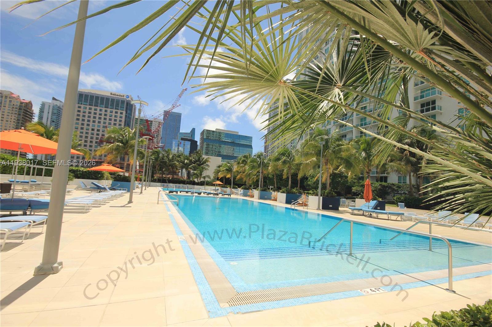 950 Brickell Bay Drive, Unit 5505 Miami, FL 33131 - Photo 42 of 63 a view of a swimming pool with a lawn chairs under an umbrella