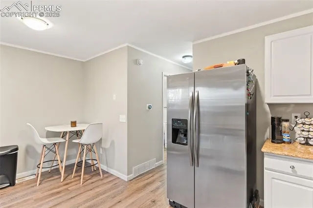 a kitchen with a refrigerator and table chair