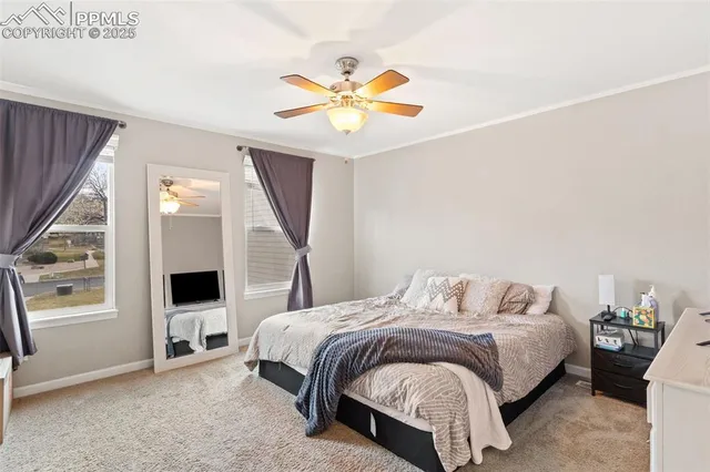 a bedroom with a bed a window and a ceiling fan
