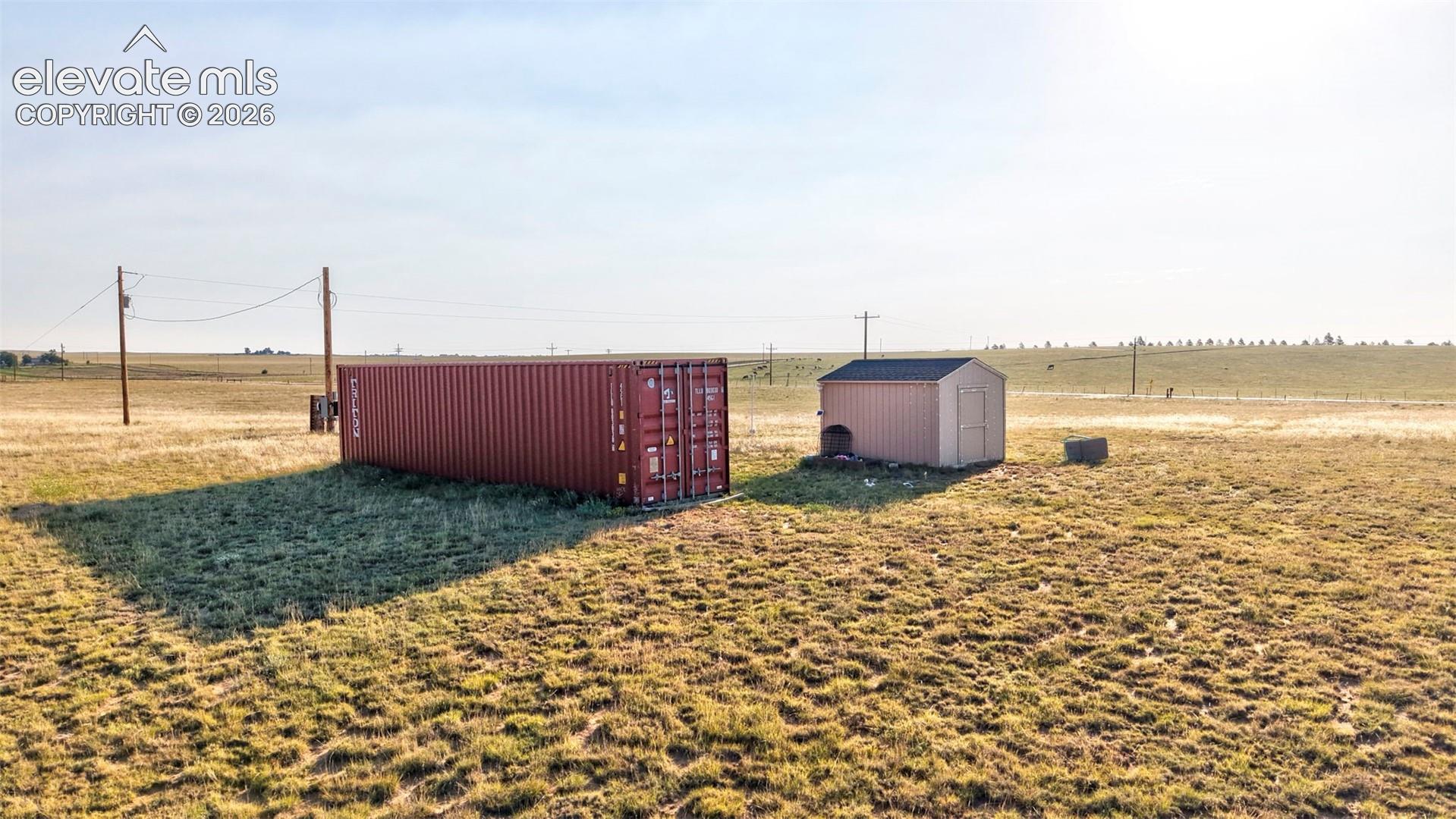 9670 Boone Road Yoder, CO 80864 - Photo 17 of 17 Expansive open land featuring a red shipping container and a tan storage shed