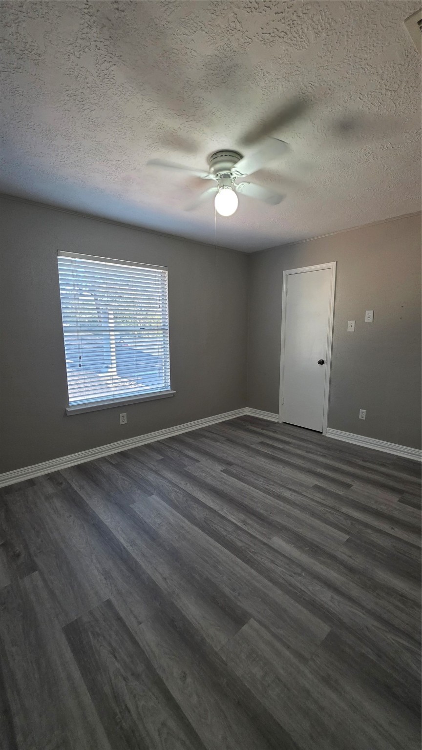 16403 Salinas Lane Houston, TX 77095 - Photo 13 of 17 an empty room with wooden floor chandelier fan and windows