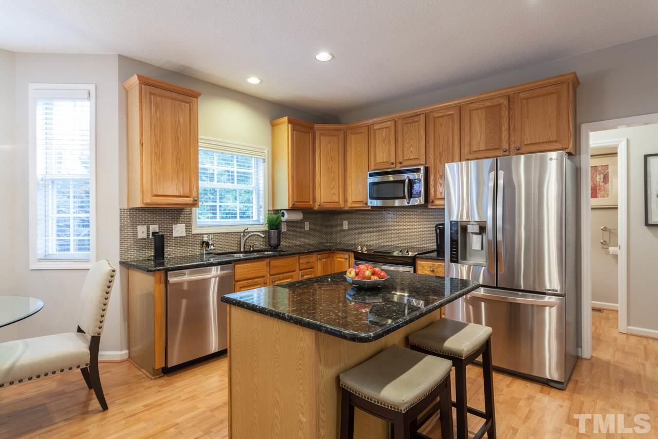8523 Guerro Court Raleigh, NC 27613 - Photo 11 of 25 Kitchen boasts granite counters, glass tile backsplash, stainless steel appliances, island with great storage and huge pantry!