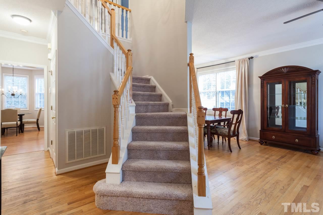 8523 Guerro Court Raleigh, NC 27613 - Photo 5 of 25 Spacious foyer with attractive angled staircase provides a welcoming entryway with views of living, dining and into kitchen and family spaces.
