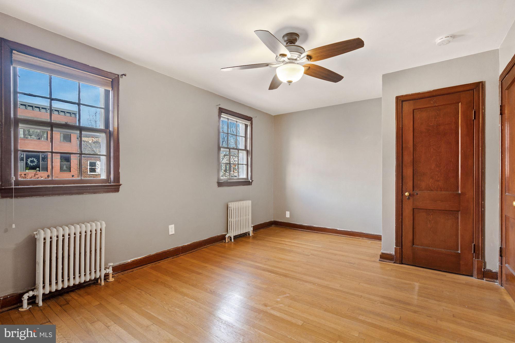 1403 K Street Southeast Washington, DC 20003 - Photo 47 of 74 an empty room with wooden floor chandelier fan and windows