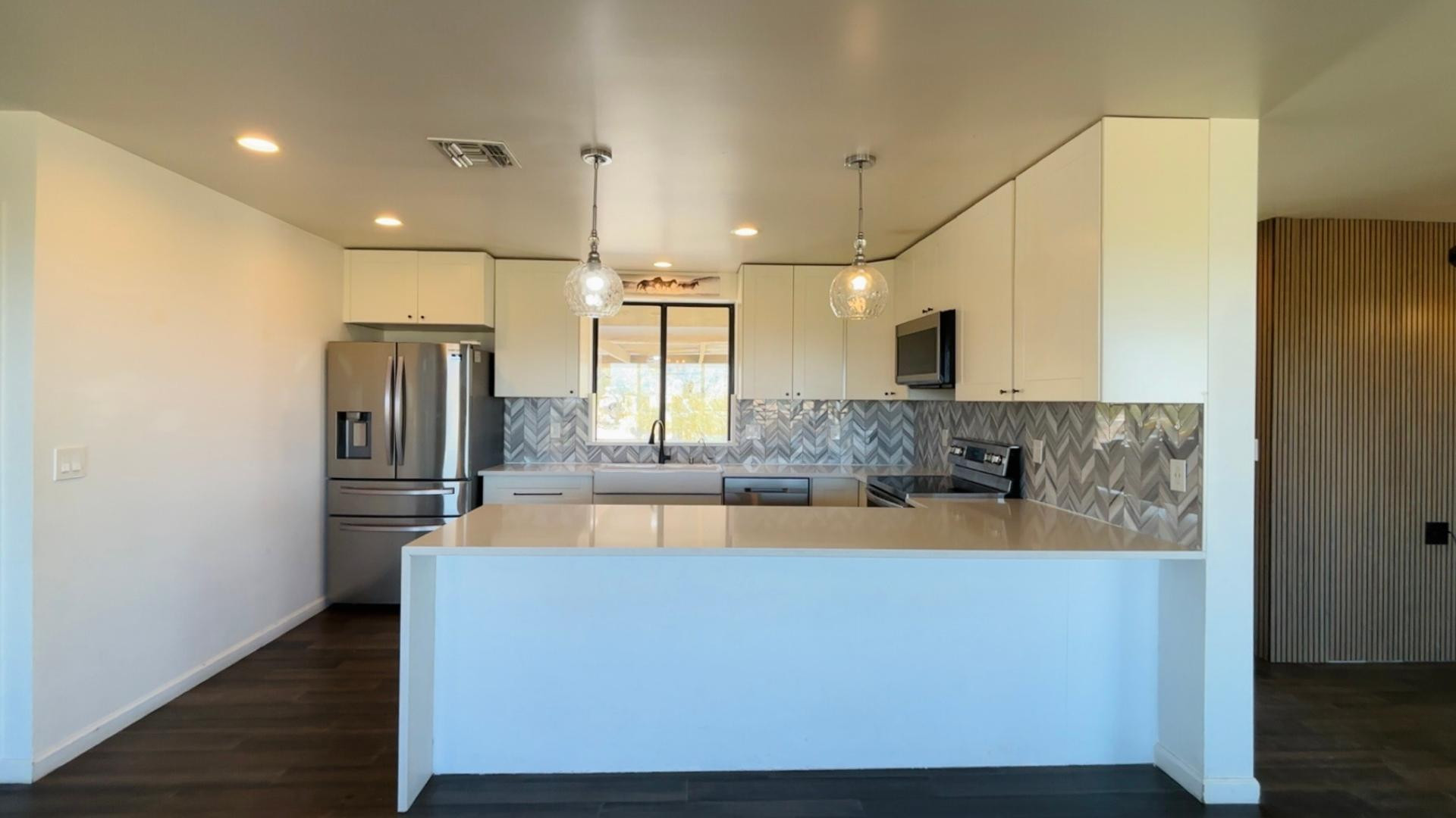 1750 West Pearce Road Phoenix, AZ 85041 - Photo 11 of 39 a large kitchen with stainless steel appliances granite countertop a refrigerator a oven and a sink with wooden floor