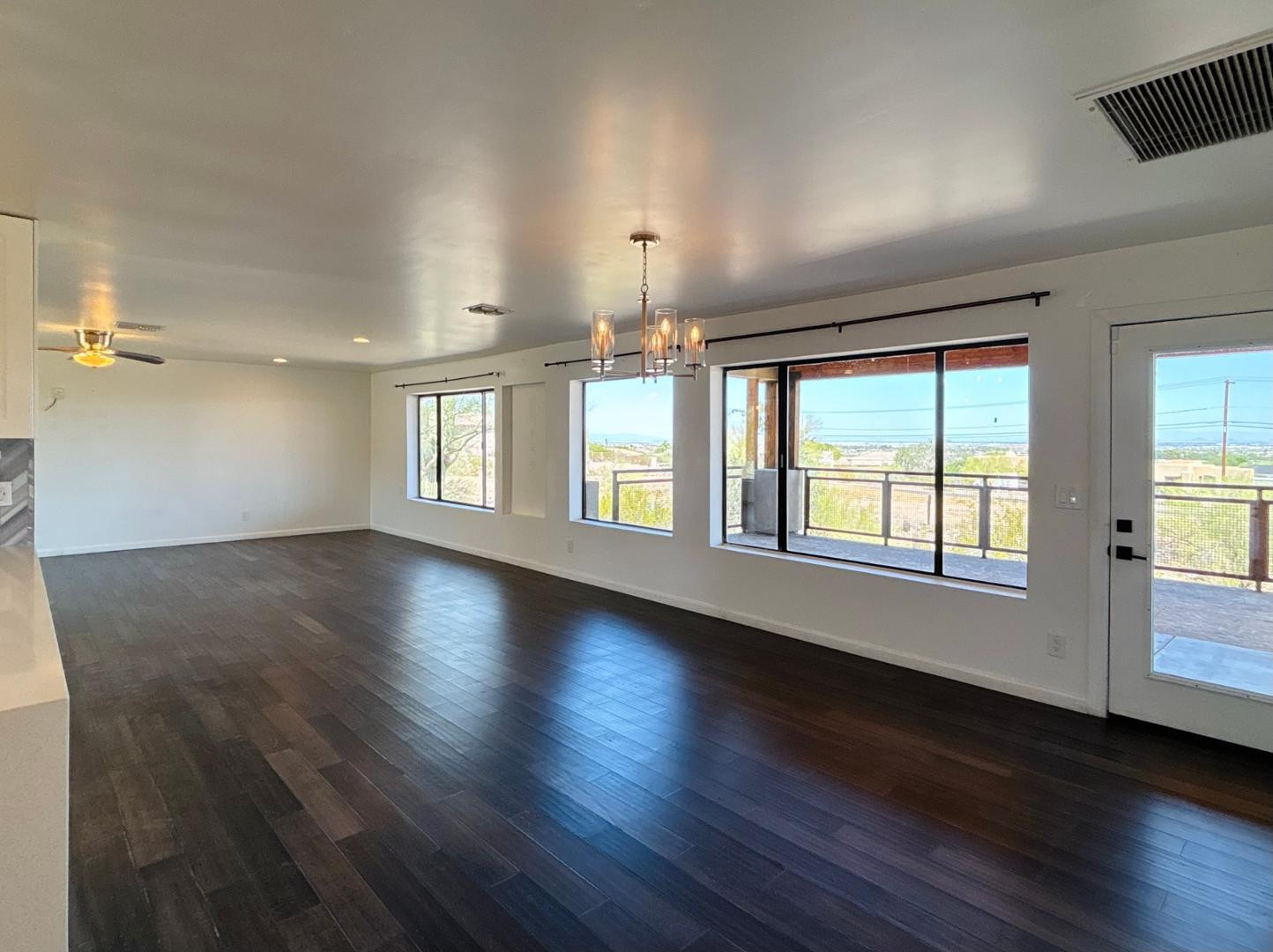 1750 West Pearce Road Phoenix, AZ 85041 - Photo 15 of 39 an empty room with wooden floor and windows