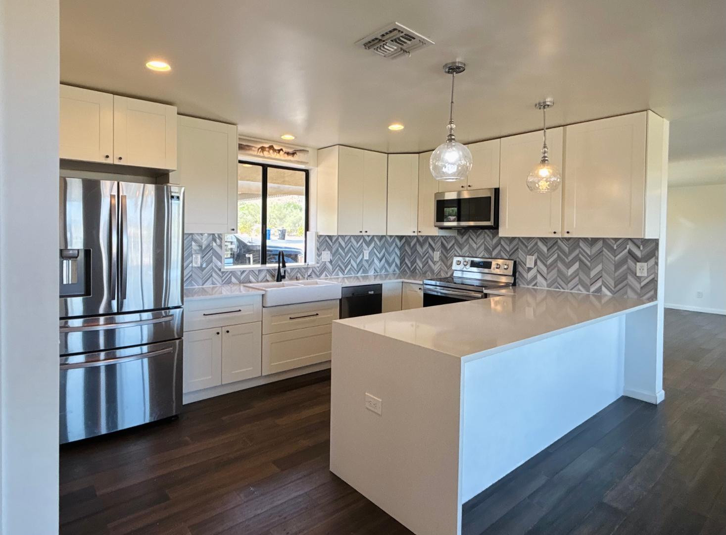 1750 West Pearce Road Phoenix, AZ 85041 - Photo 18 of 39 a kitchen with kitchen island white cabinets and stainless steel appliances