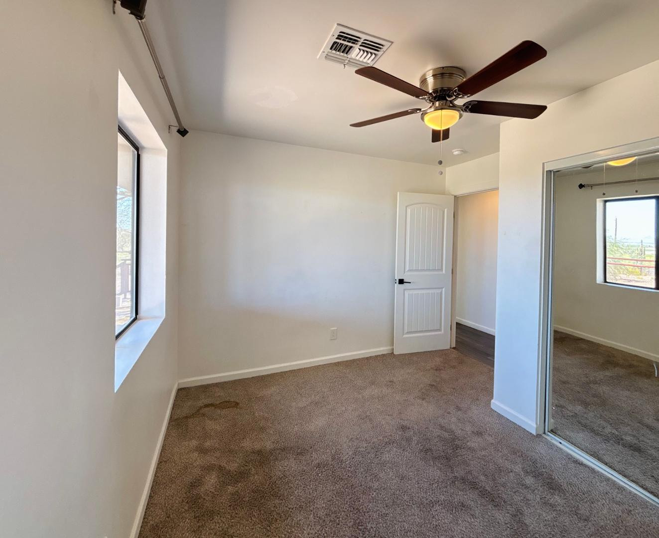 1750 West Pearce Road Phoenix, AZ 85041 - Photo 26 of 39 an empty room with windows and fan