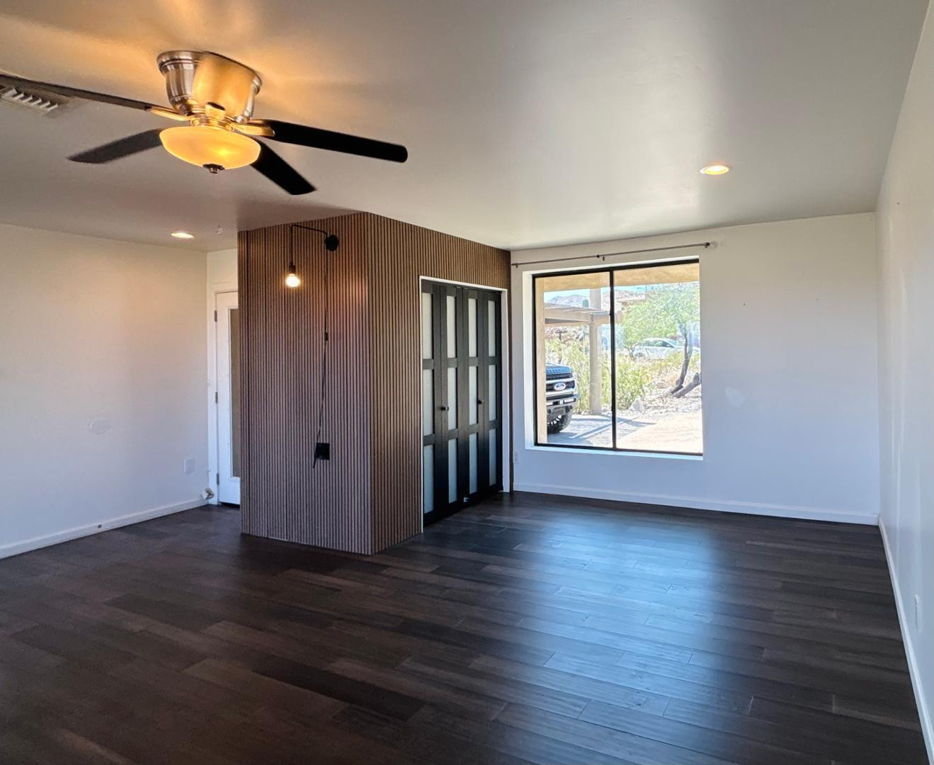1750 West Pearce Road Phoenix, AZ 85041 - Photo 9 of 39 a view of an empty room with wooden floor and a window