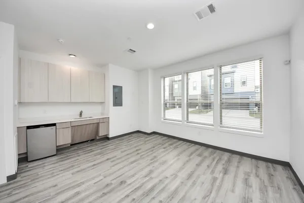 a large kitchen with cabinets wooden floor and stainless steel appliances