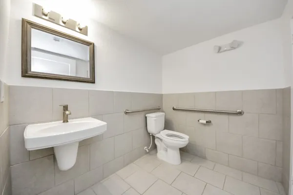 a bathroom with a toilet sink and mirror