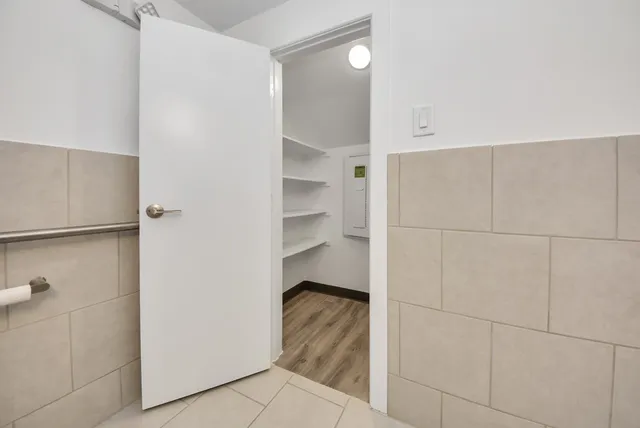 a room with a walk in closet and wooden floor