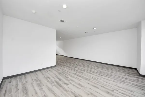 a view of an empty room with wooden floor