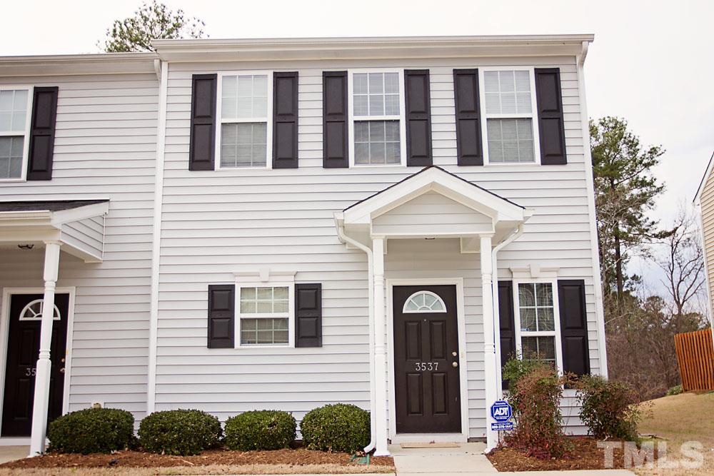 a view of a brick house with a yard