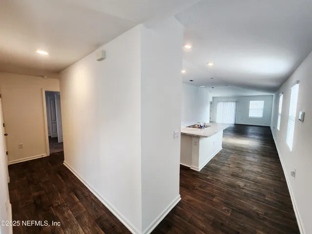 a kitchen with a sink stove and wooden floor
