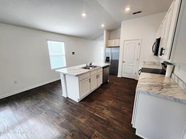 a kitchen with a stove and a wooden floors