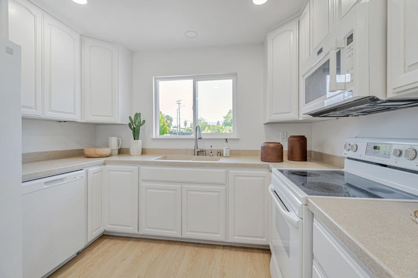 1069 Linda Drive Campbell, CA 95008 - Photo 9 of 39 a kitchen with stainless steel appliances granite countertop a sink dishwasher a stove and white cabinets with wooden floor